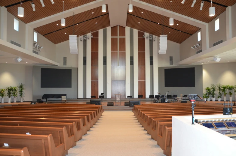 a church with high ceilings, wooden pews and wood chairs