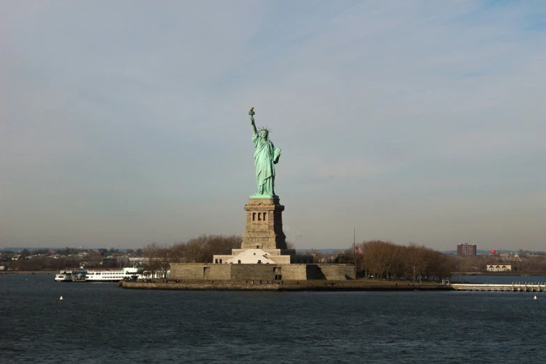 the statue of liberty looks very peaceful with the beautiful blue skies in the distance
