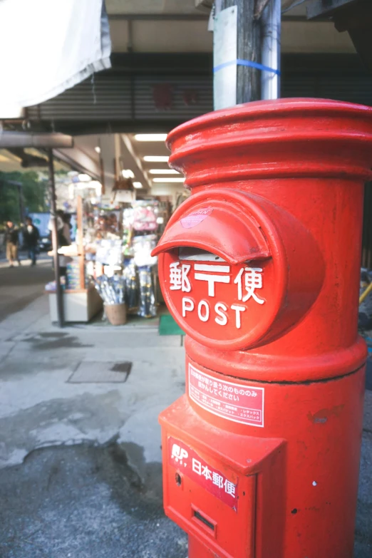 a red post box sitting in front of a store