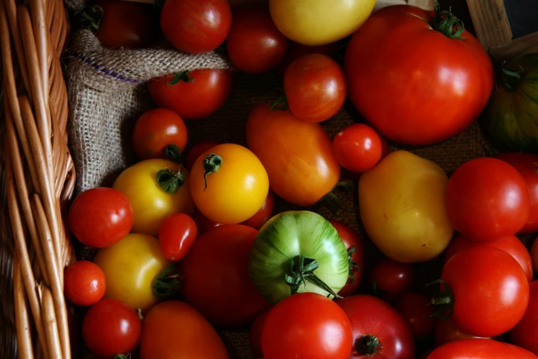 tomatoes and other vegetables displayed in wicker baskets