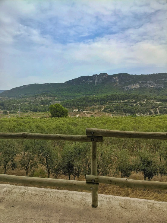 a wooden fence near a lush green hillside