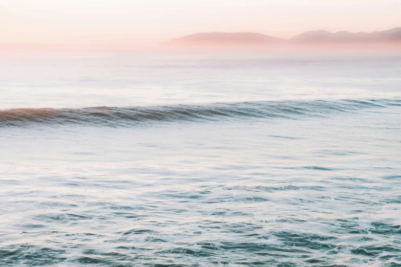 a surfboard rides on top of a wave in the ocean