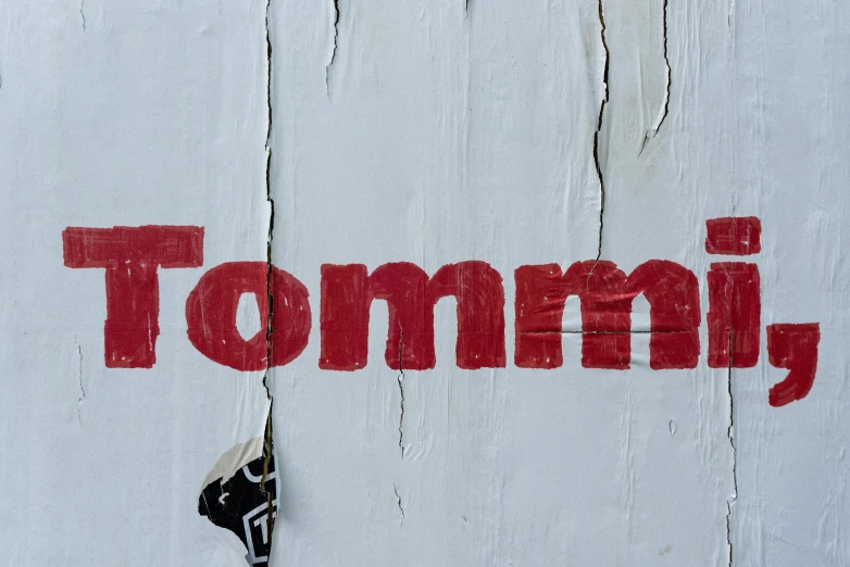 some paint and a piece of wood with the word tommy on it