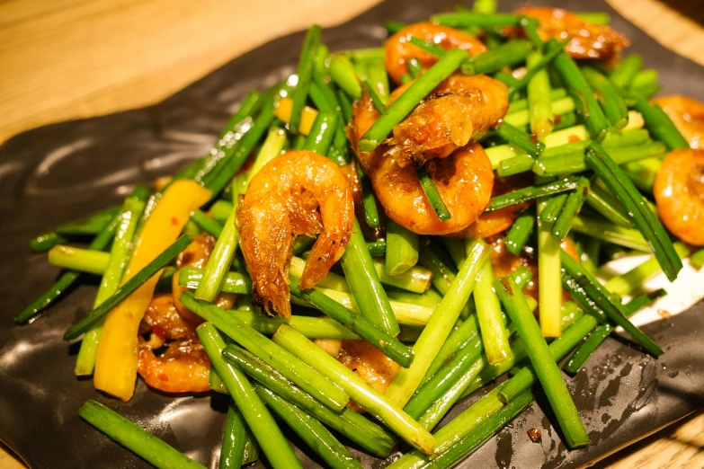 a plate is holding stir fried vegetables on a wooden table