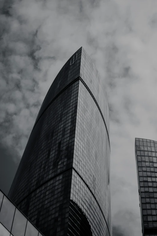 looking up at two skyscrs against a cloudy sky