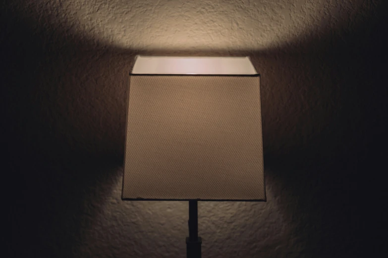 a lamp that is lit in the dark with only one light on