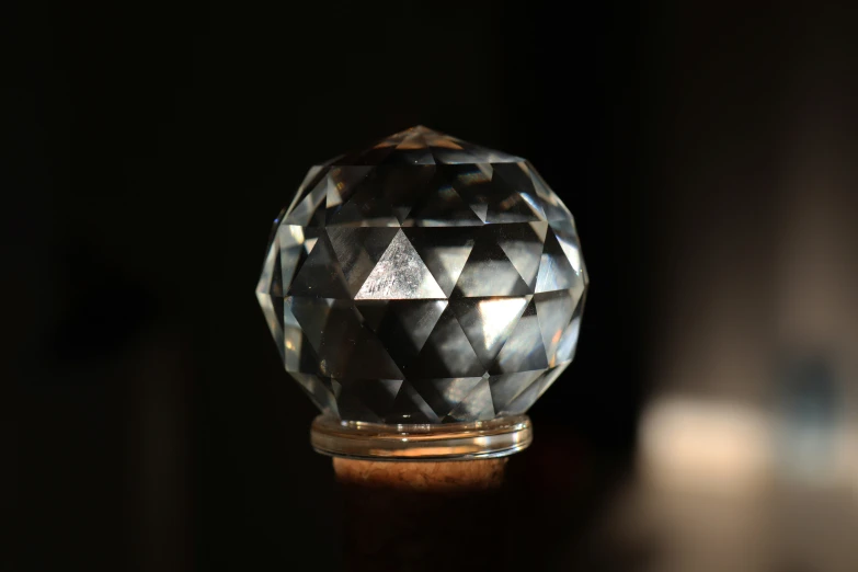 a unique black crystal crystal sphere on top of a wooden table