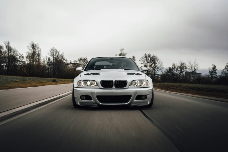 the front end of a silver bmw in motion