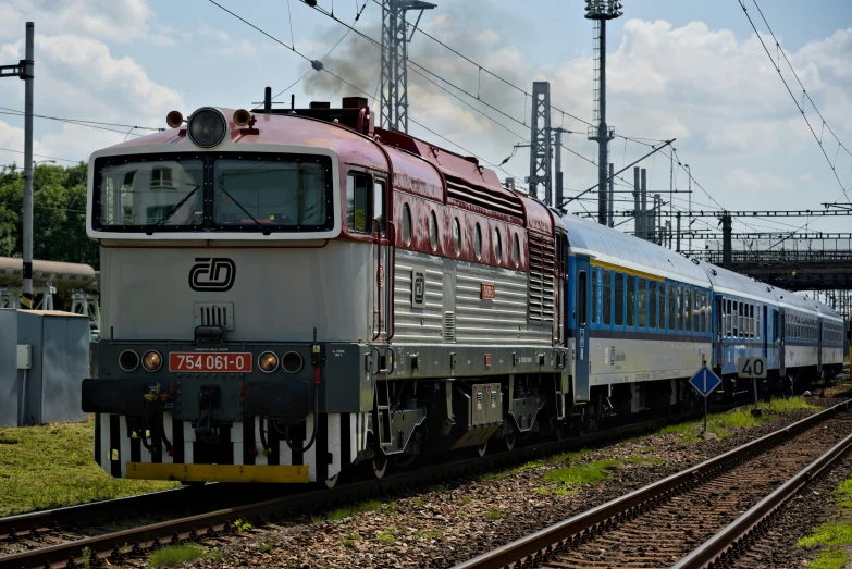 an old, colorful passenger train traveling through the countryside