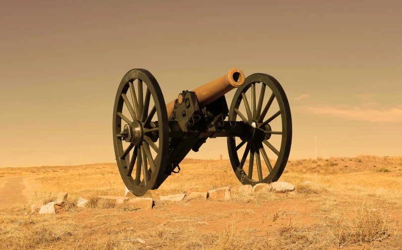 a close up of an old gun in the middle of the desert