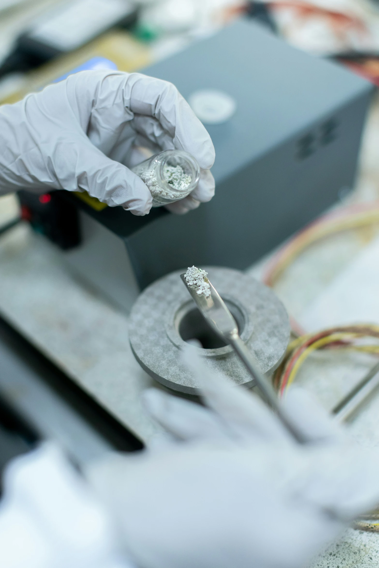 person wearing protective gloves using scissors on wires