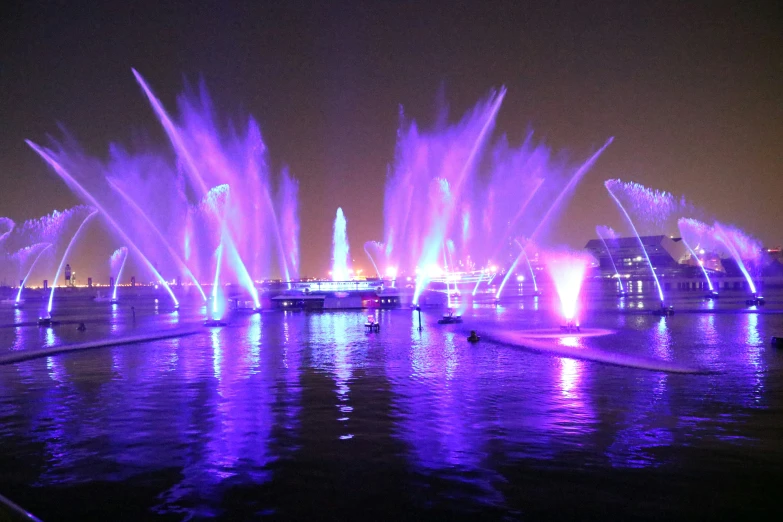 a fountain lit up purple and purple lights