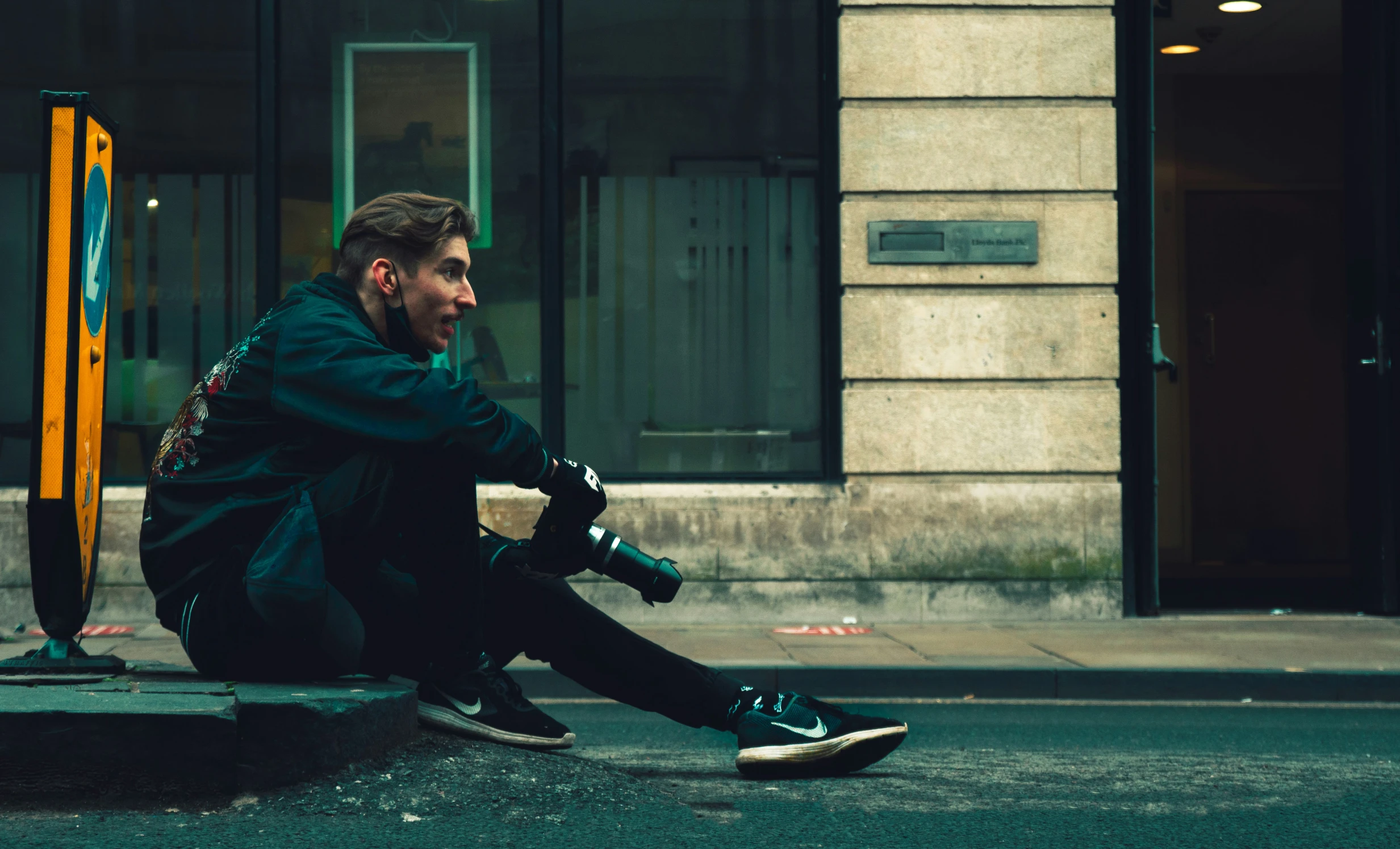 a person sitting on the ground in front of a building