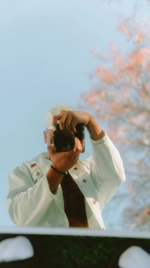 a man takes a picture with his camera while looking out the window