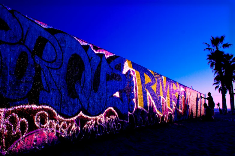 a group of people standing next to a graffiti covered wall