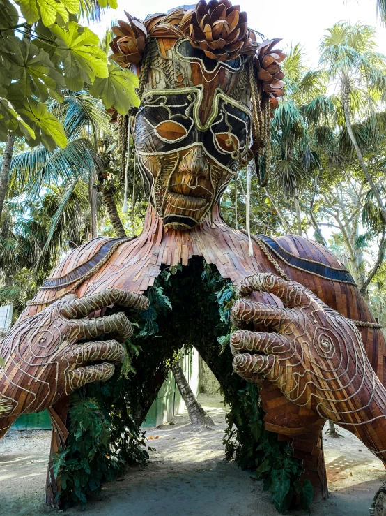 a statue made of woven cloth, holding up his hands