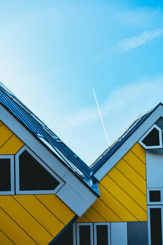 two wooden buildings with a bright yellow roof against a blue sky