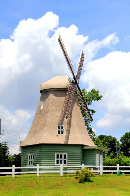 a small building with an old fashioned windmill on top of it