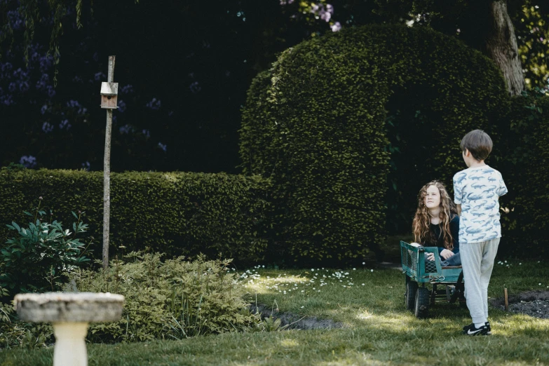 two people are walking down a grassy yard