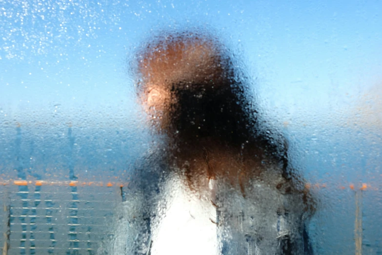 blurry pograph of woman behind window on sunny day