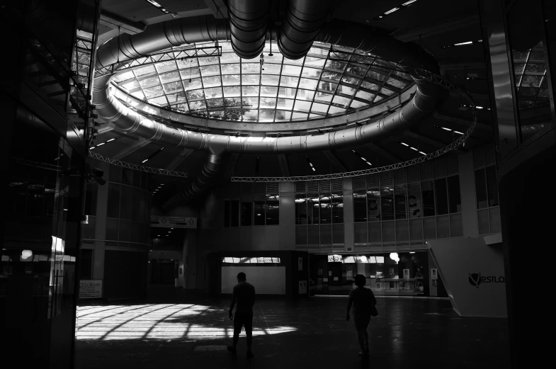 black and white po of two people walking in large building