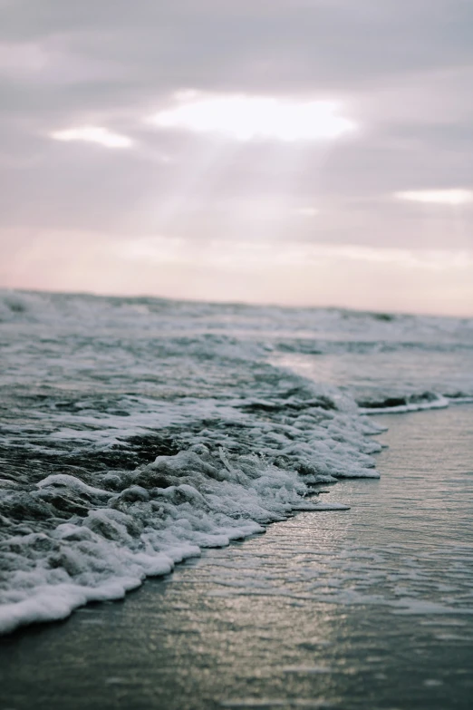 a surfer is walking through the water towards the shore