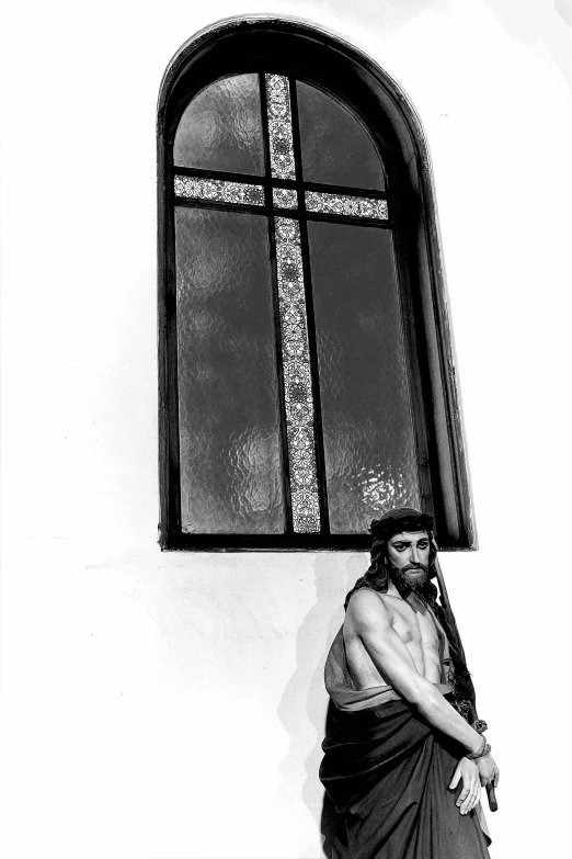 a man standing next to a window near a building