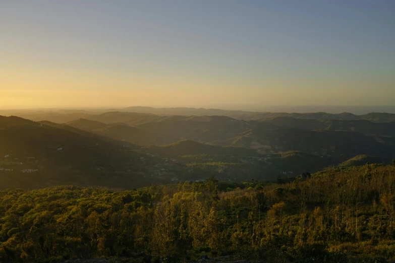 a hazy sky and mountains seen from a high up viewpoint