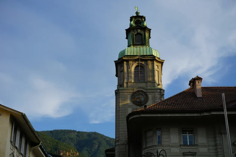 a building with a large steeple surrounded by mountains