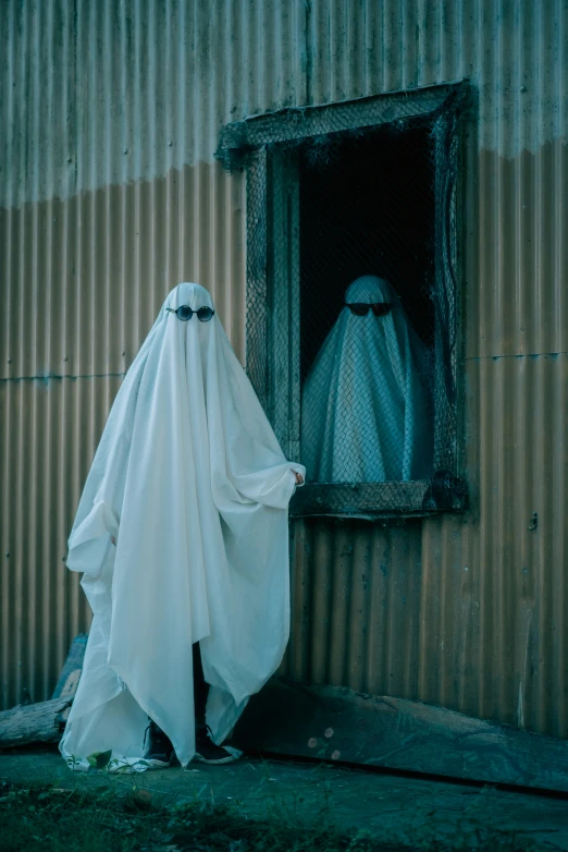 a woman wearing white is staring out a window