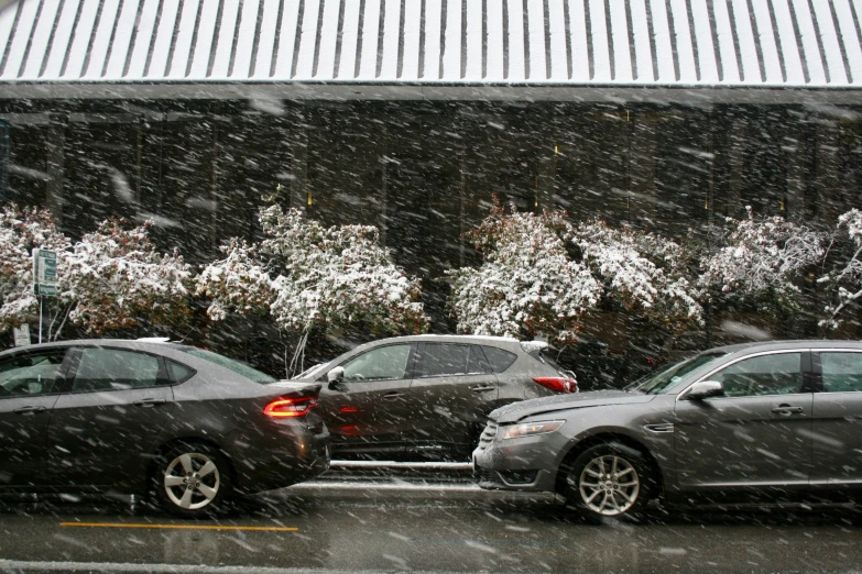 a parking lot with two cars covered in snow