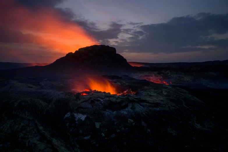 the mountain has fire coming from its blaze and clouds