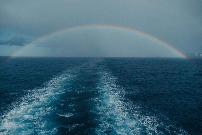 a rainbow appears on the side of the boat as it passes by