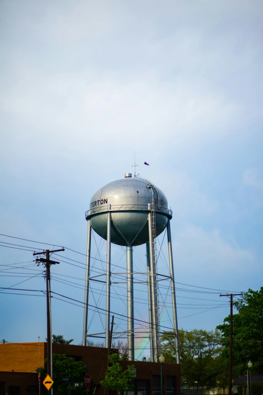 a silver water tower on top of a pole