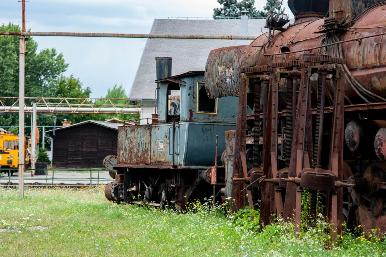 a rusted train engine sitting on top of green grass