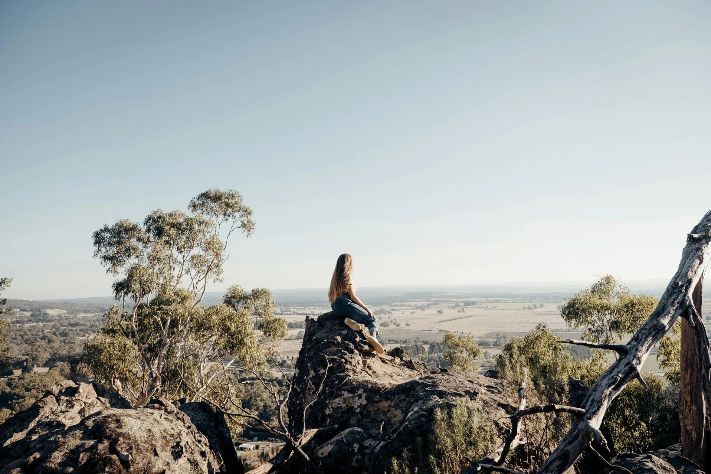 a woman on top of a rock with her  out