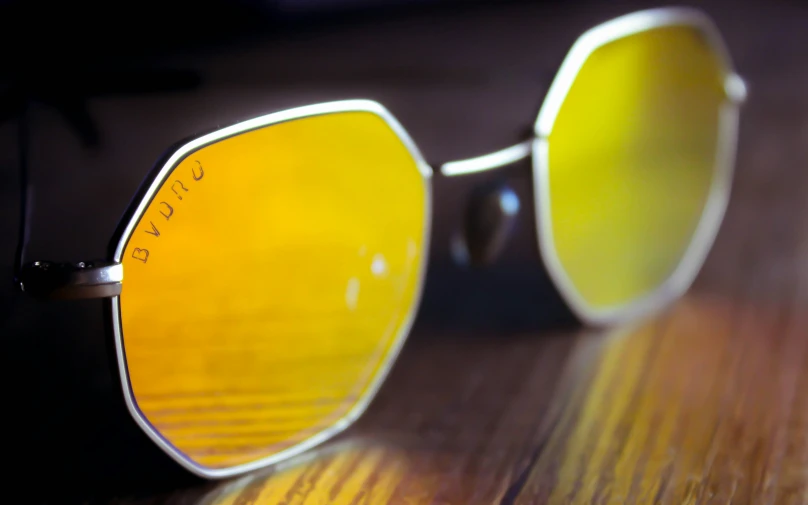 a pair of sun glasses sits on a wood table