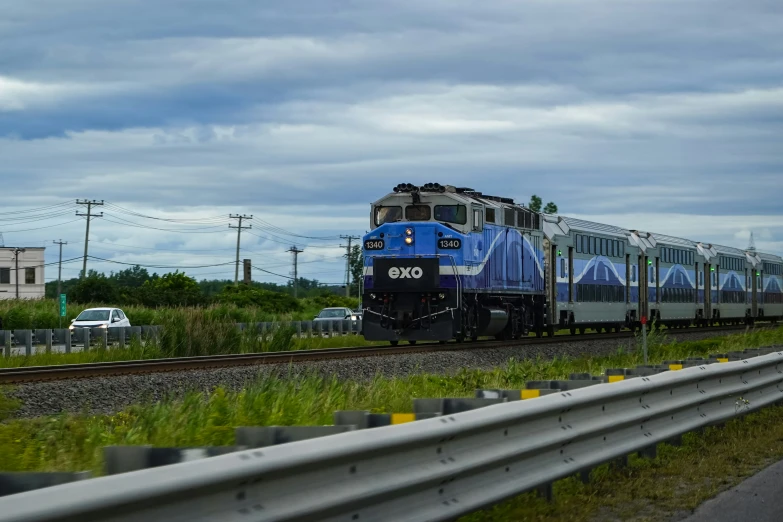 a train on a track with a cloudy sky in the background