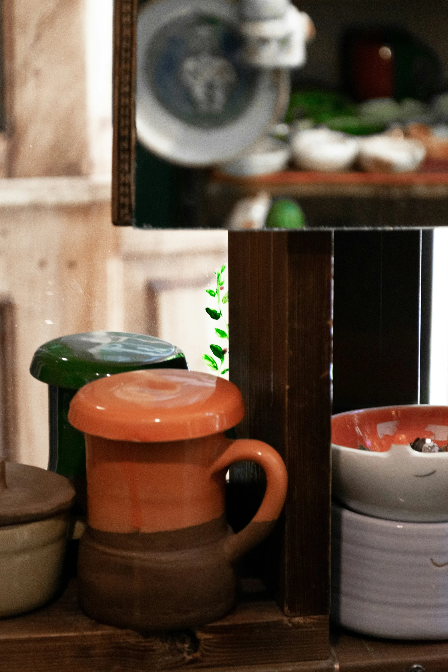 an assortment of orange and white plates, bowls and vases