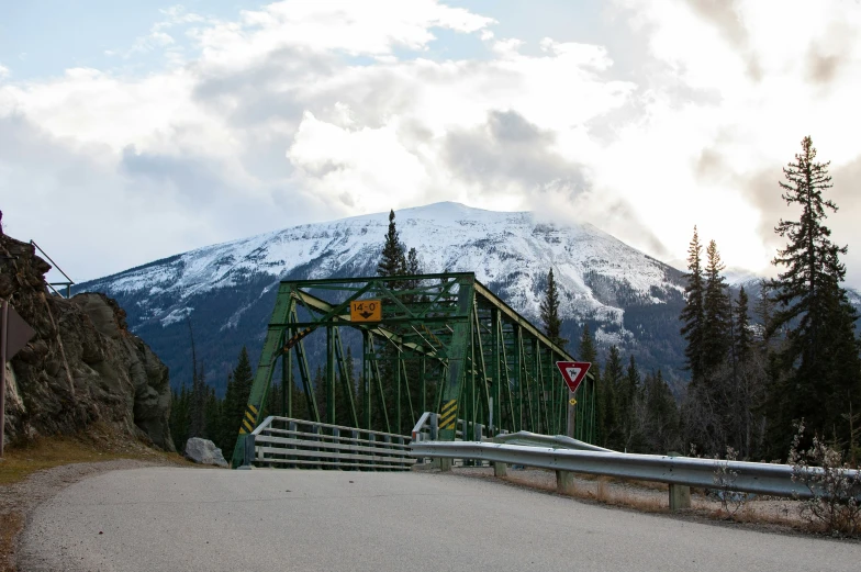 a green bridge with mountain in the background