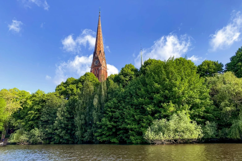a very tall church sitting between some green trees