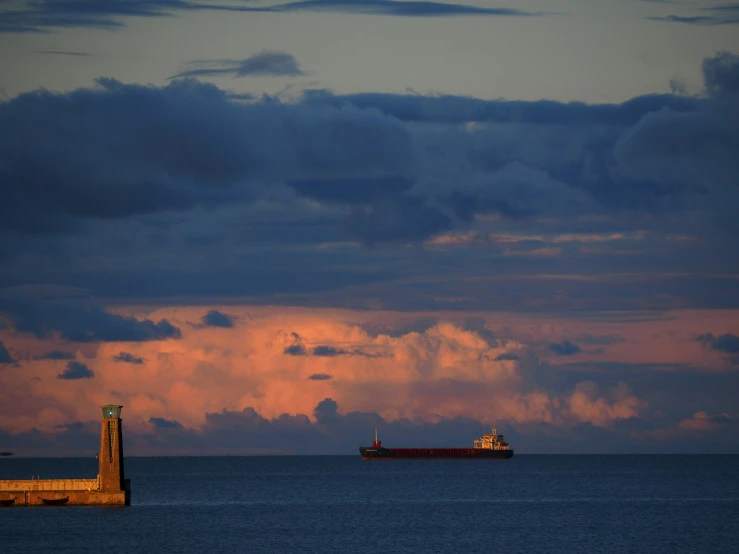 a boat floating in the water with a sky in the background