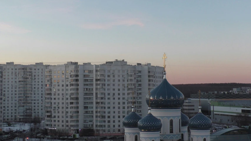 a big building with some tall buildings in the background