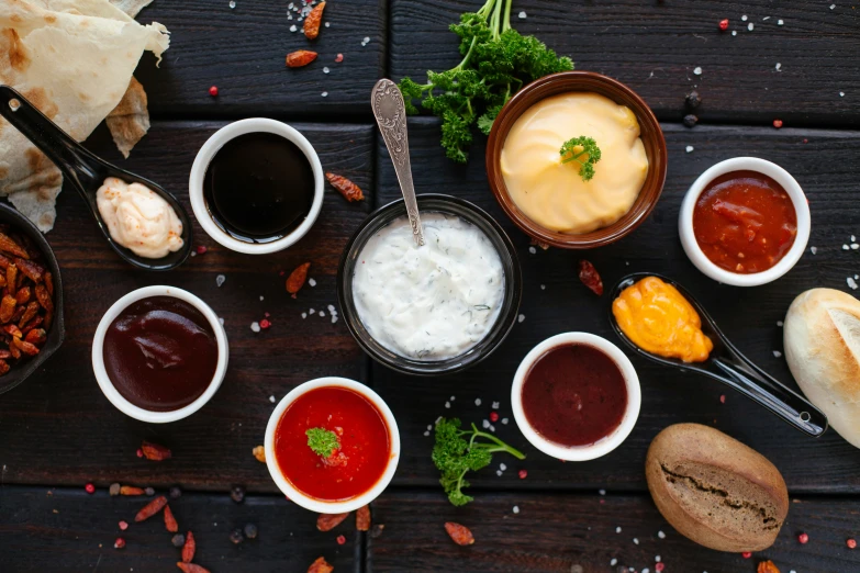 various condiments sit on a dark surface