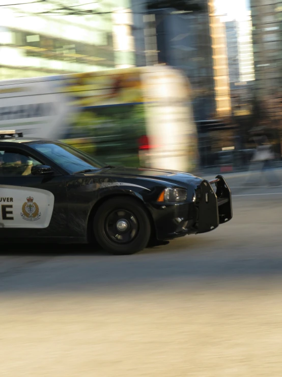 a police car is driving down the street in an urban area