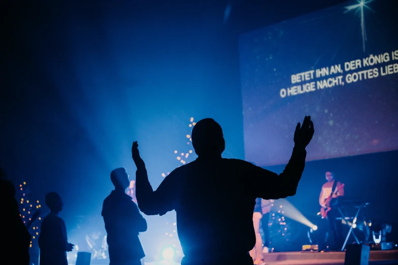 a man raising his arms on stage