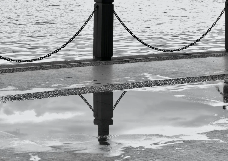 a black and white po of a clock pole and water