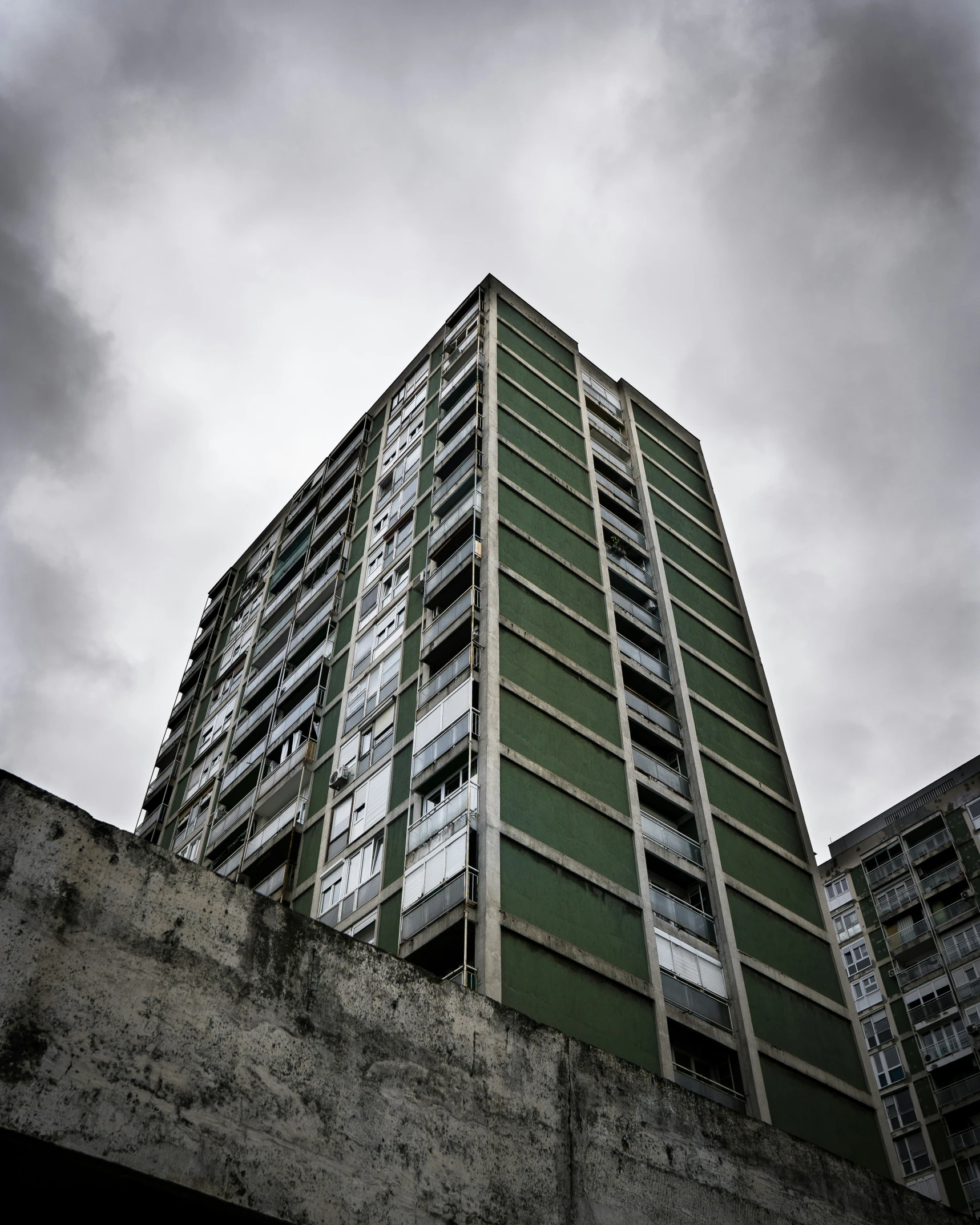 an old building is shown from the ground, with cloudy skies above