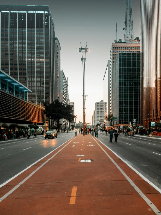 a city street with people crossing it in the evening