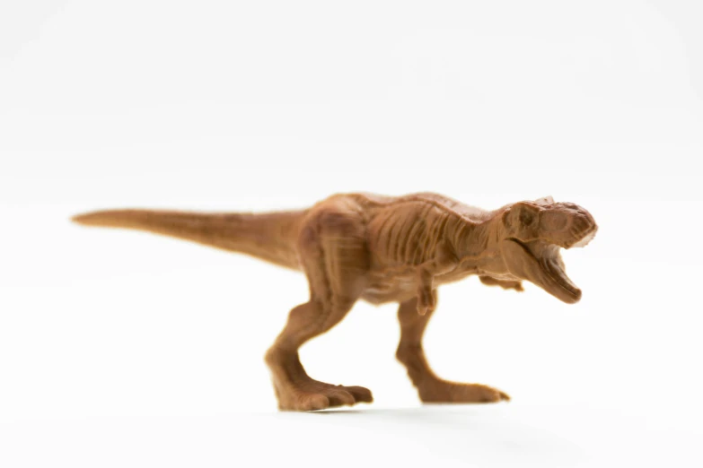 a toy dino on a white background